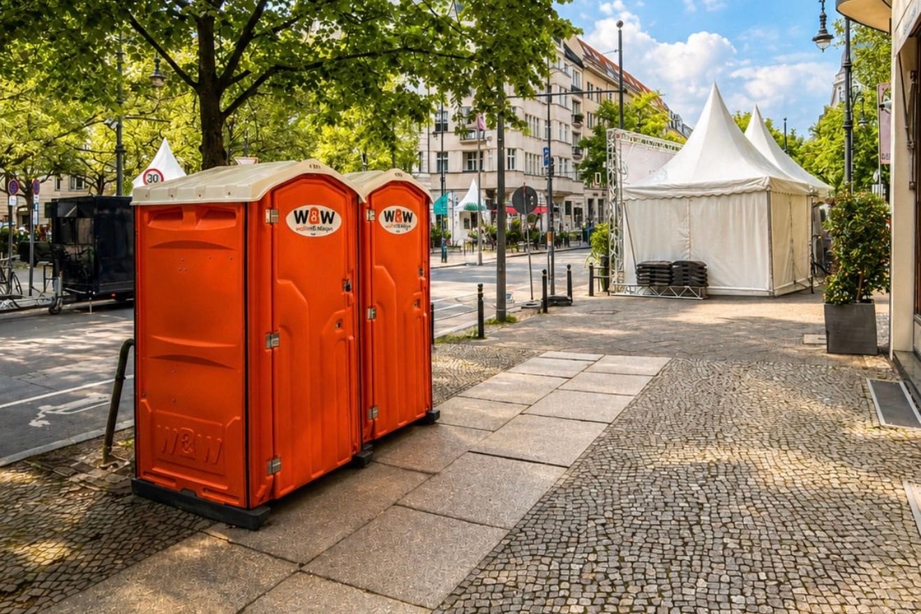 Two W&W toilet cabins on Kurfürstendamm in front of event marquees